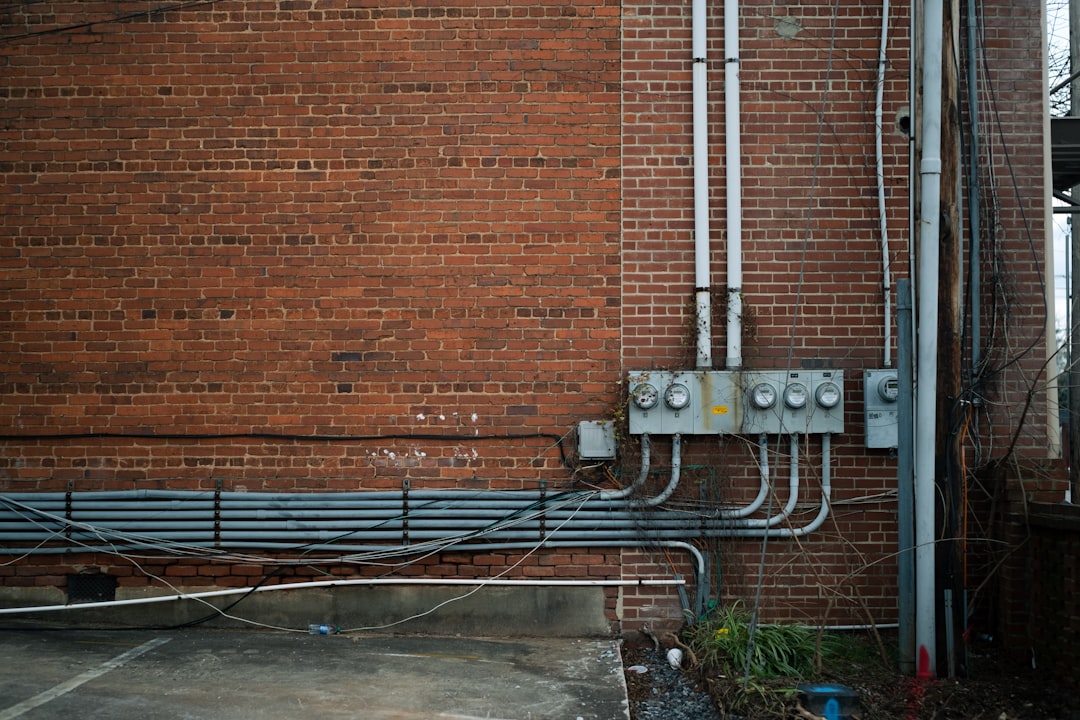 Electrical Testing Instalasi - a red brick building with pipes and wires attached to it