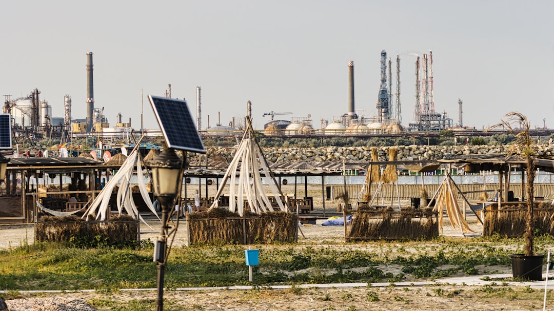 Water Level Monitoring - Beach huts are in front of an industrial landscape.