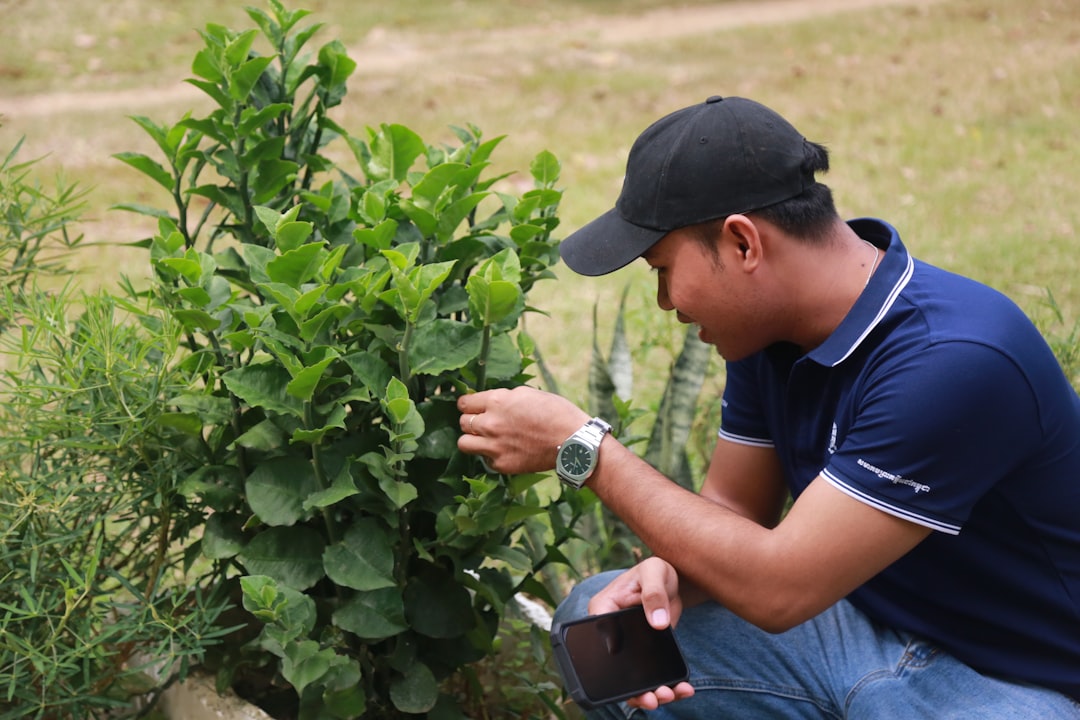 A man kneeling down next to a tree