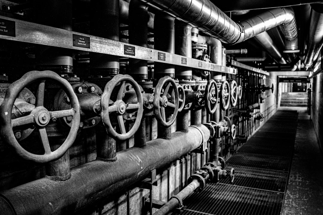 Industrial valves and pipes in a dark corridor.