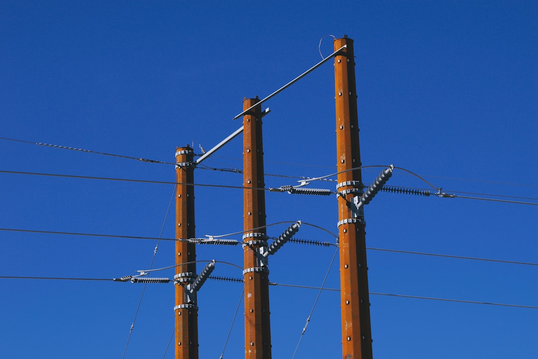 Wooden power poles against a clear blue sky