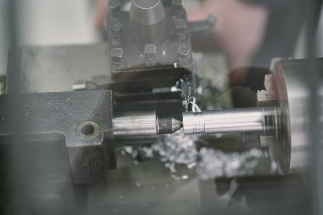 A metal lathe is actively shaping a rod.