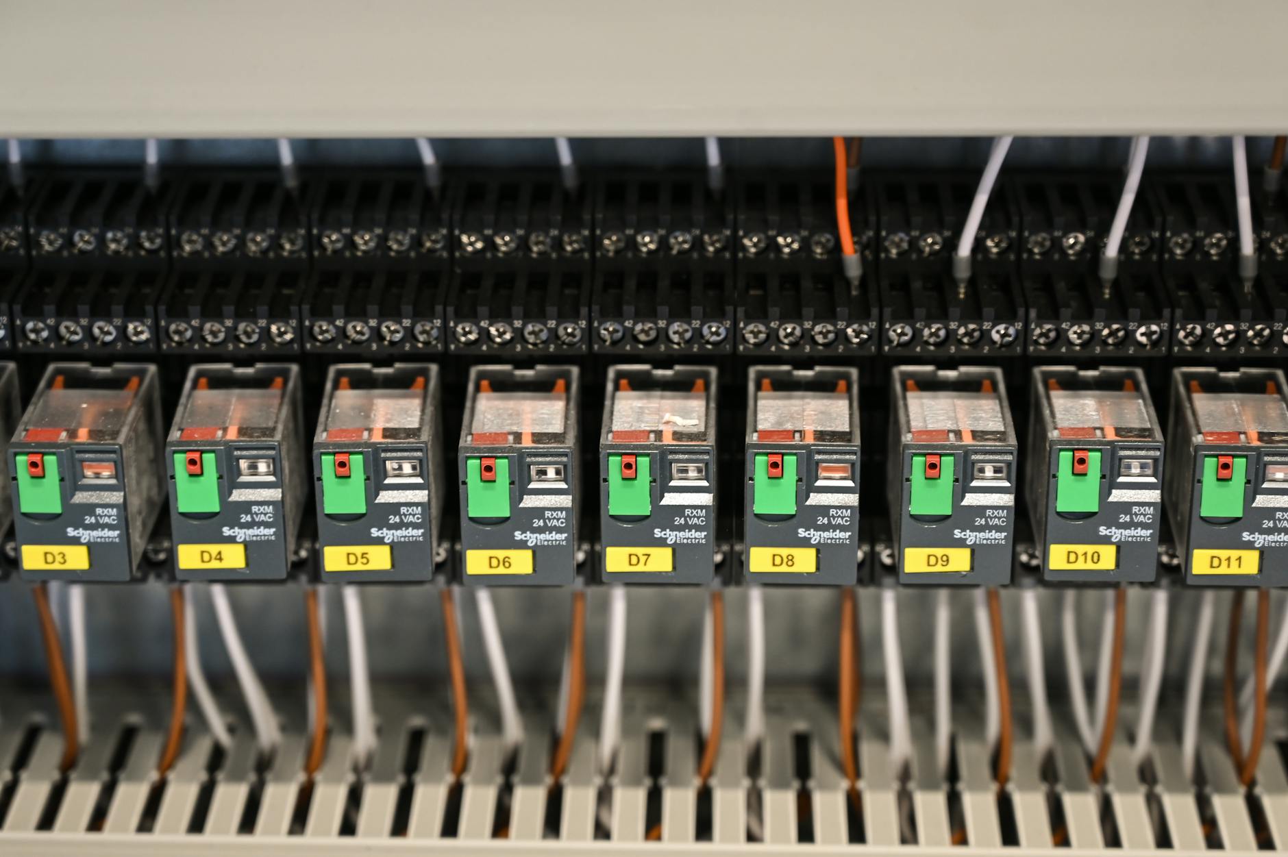 Close-up view of electrical relays in an industrial panel box showcasing circuit components.