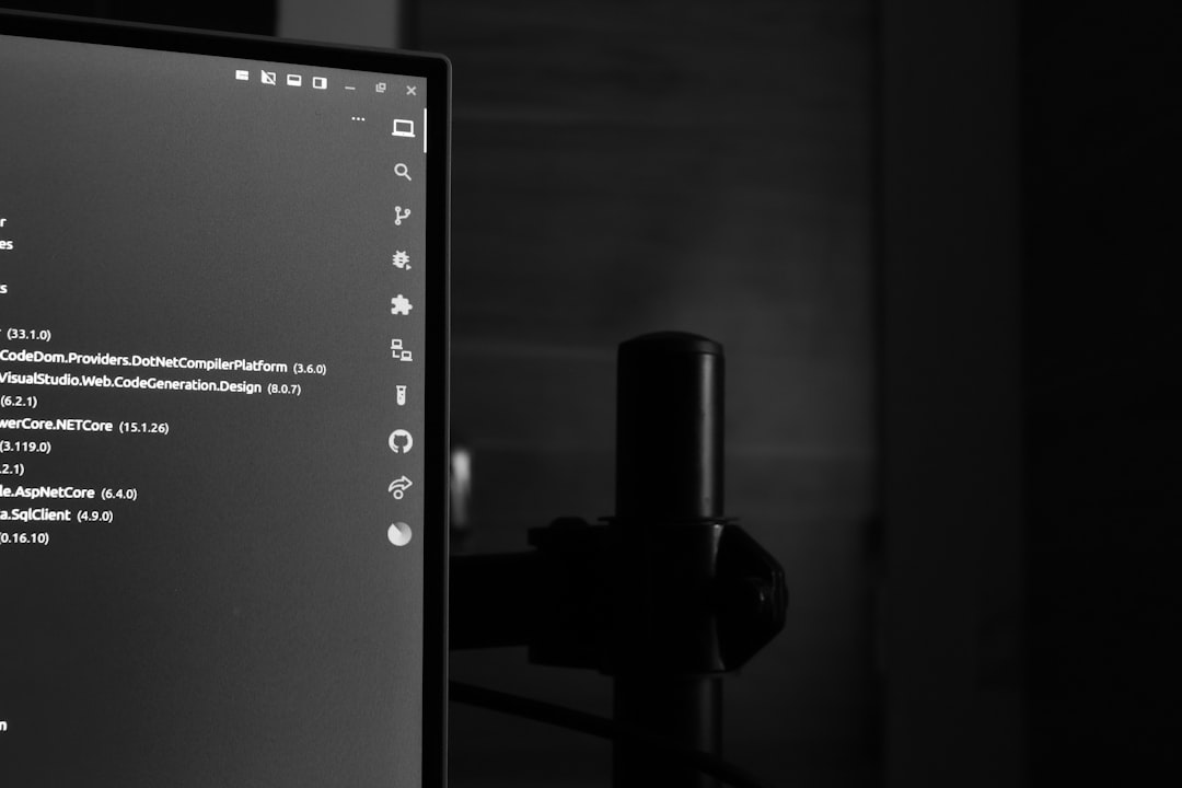 Computer monitor displaying code in a dark room.